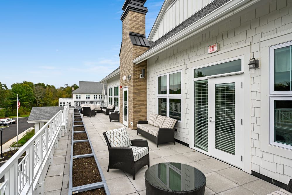 Modern outdoor patio with comfortable seating and large windows.