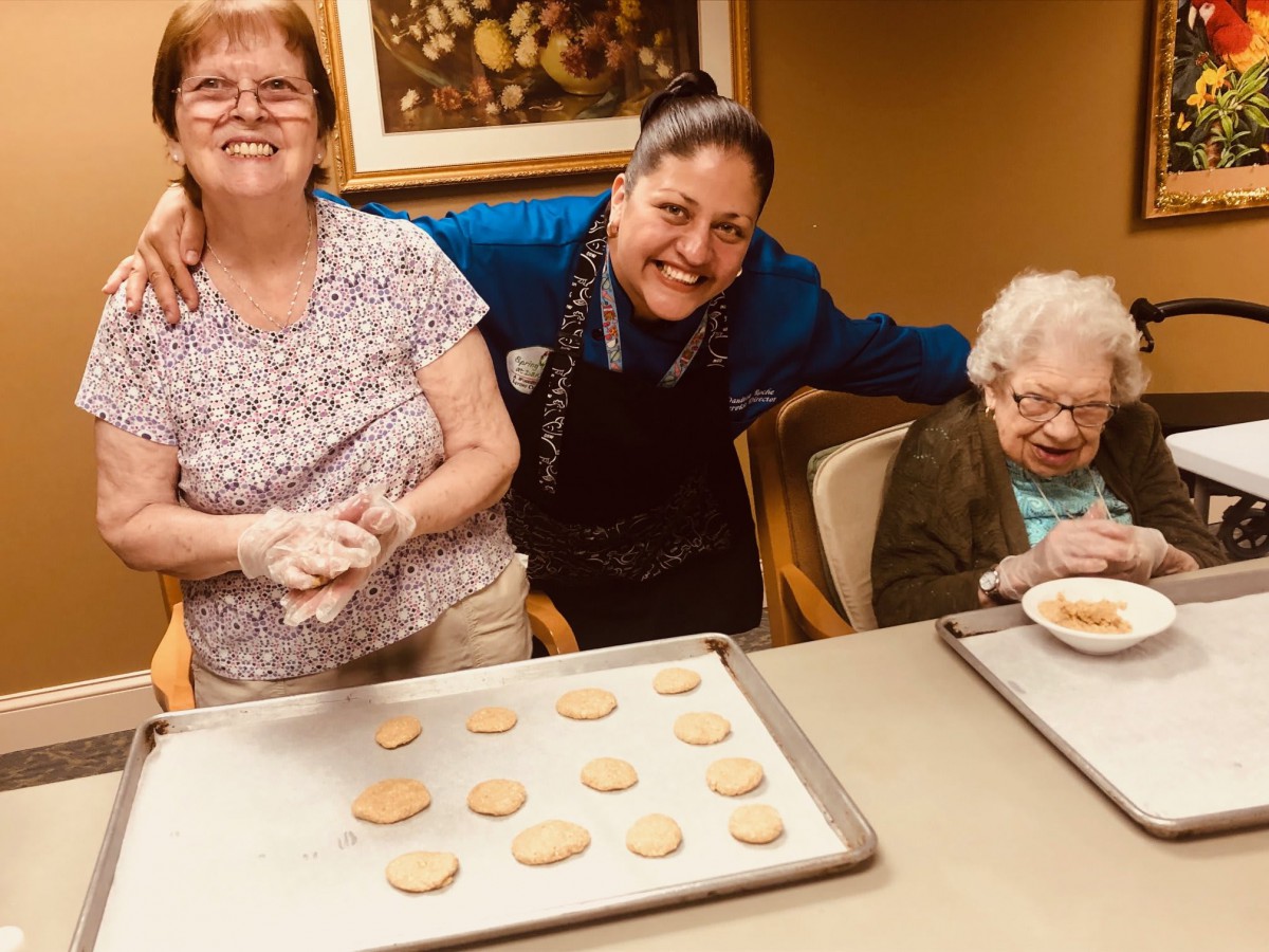 A group of people enjoying a baking session, making cookies together.