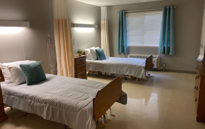 A clean hospital room with two beds and privacy curtains.