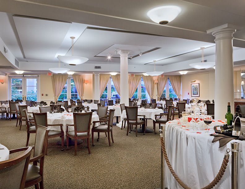 A formal dining hall set up with round tables and chairs, ready for an event.
