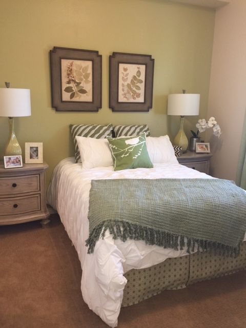 A cozy bedroom with green accents and elegant decor.