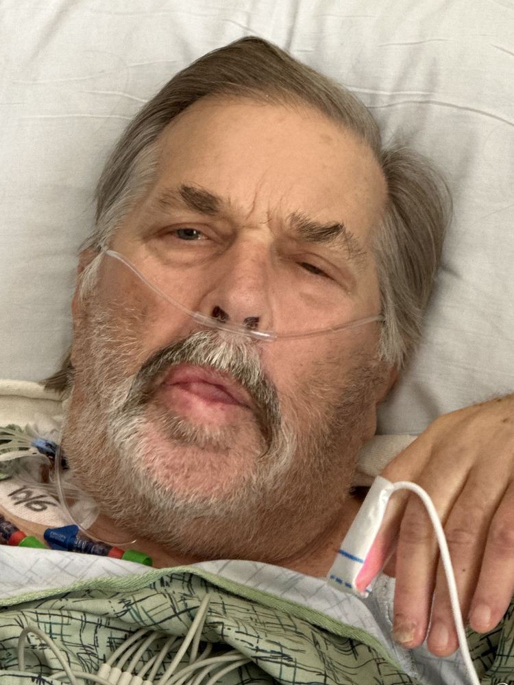 A patient resting in a hospital bed with an oxygen tube.