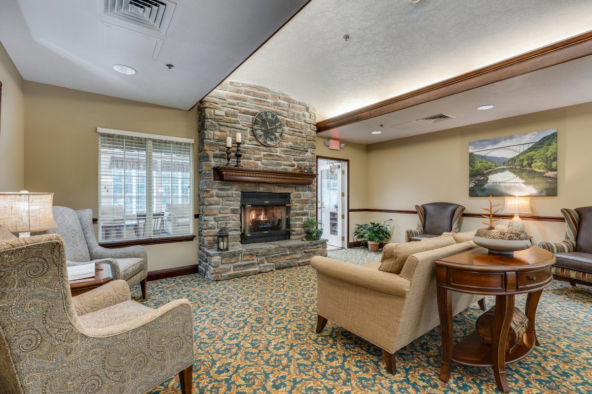 A cozy living room with a stone fireplace and comfortable seating.