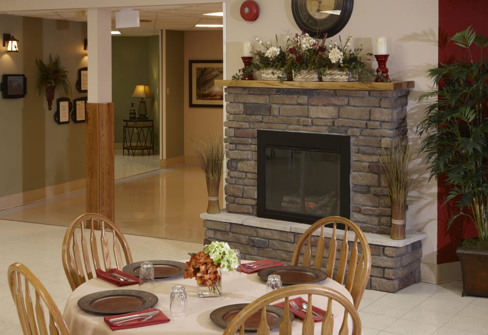 A cozy dining area featuring a stone fireplace and elegantly set tables.