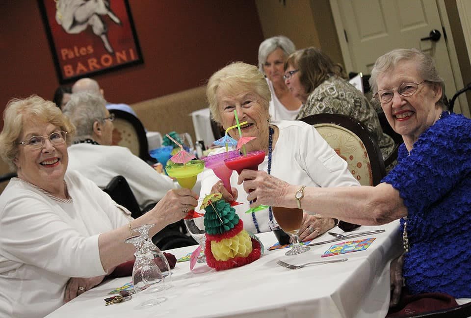A joyful group of seniors enjoying colorful drinks at a social gathering.