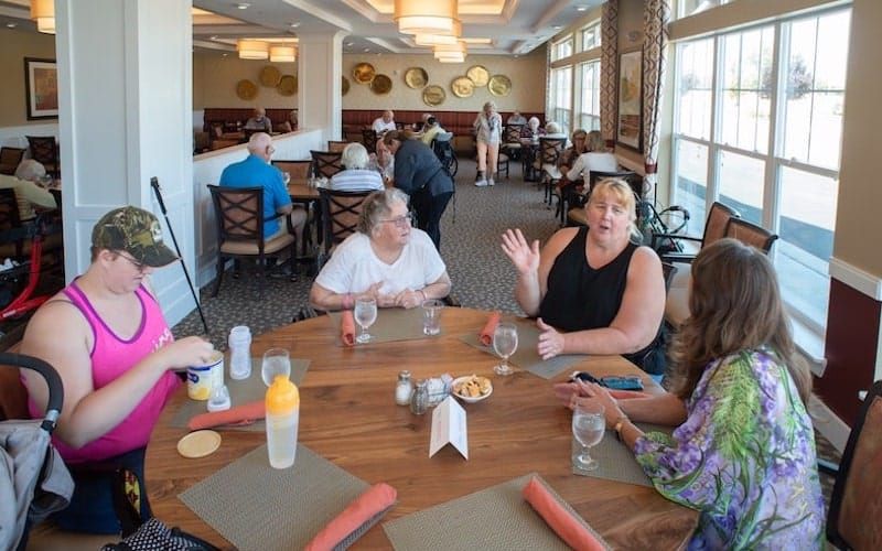 A group of people enjoying a conversation around a table in a restaurant.