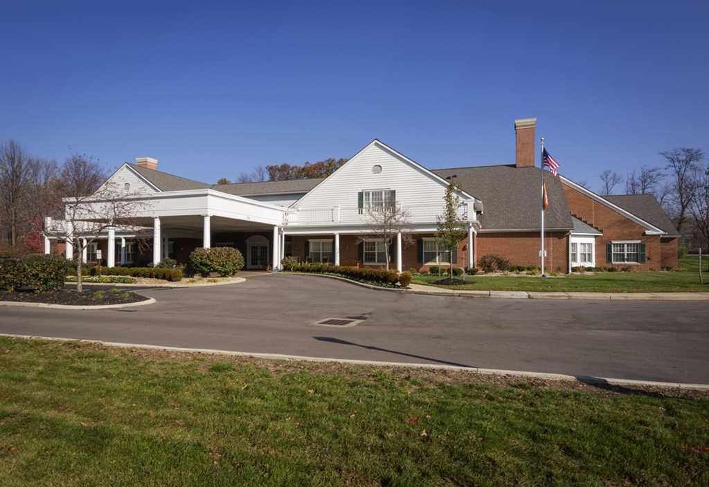 A suburban building with a covered entrance and driveway under a clear blue sky.