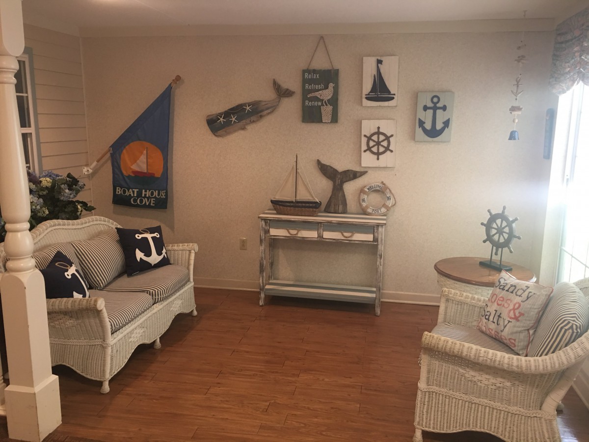 A cozy living room with nautical-themed decor and wicker furniture.