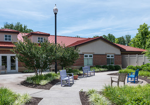 A serene outdoor space with seating and landscaped greenery in front of a building.