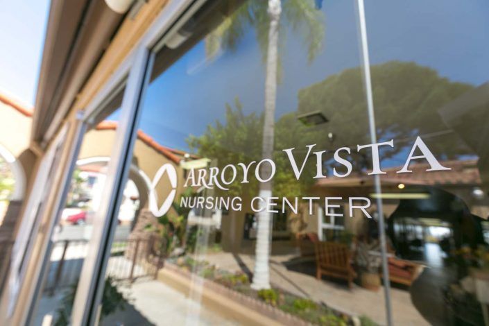 The front window of Arroyo Vista Nursing Center reflecting the surrounding environment.