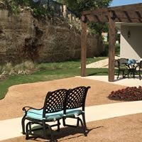 A serene patio area with a bench, pergola, and outdoor seating.