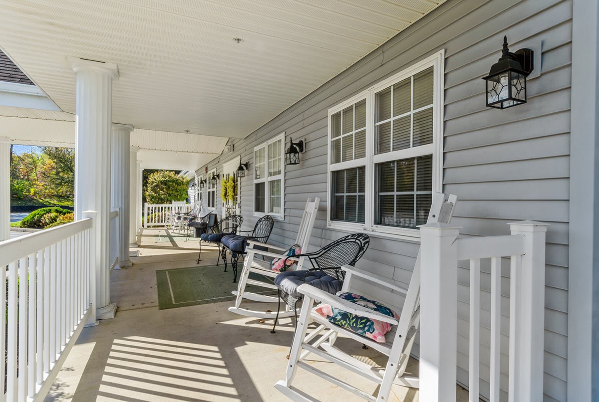 A cozy porch with rocking chairs and a view of a sunny day.