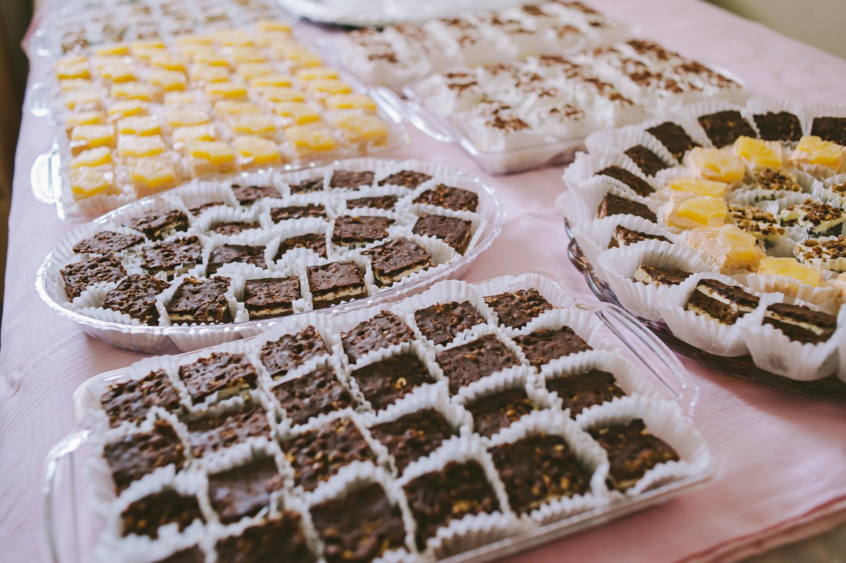 An assortment of desserts arranged on platters, featuring chocolate and coconut treats.