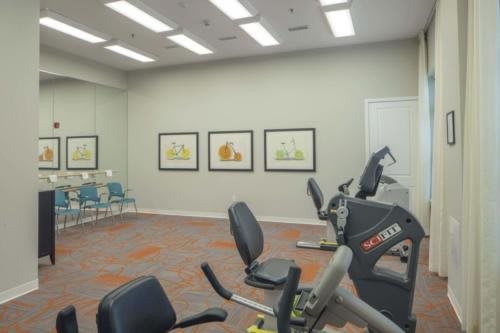 A fitness room with stationary bikes and framed artworks on the wall.