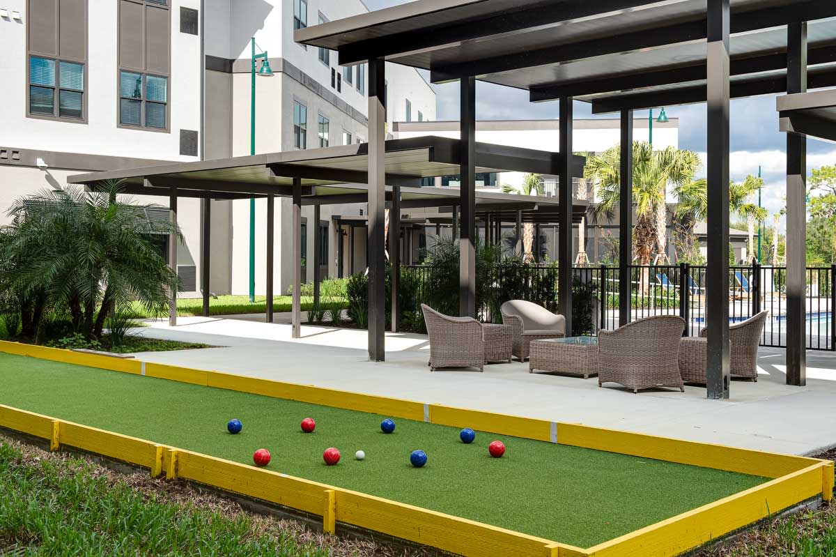 Outdoor seating area with a bocce court at an apartment complex.
