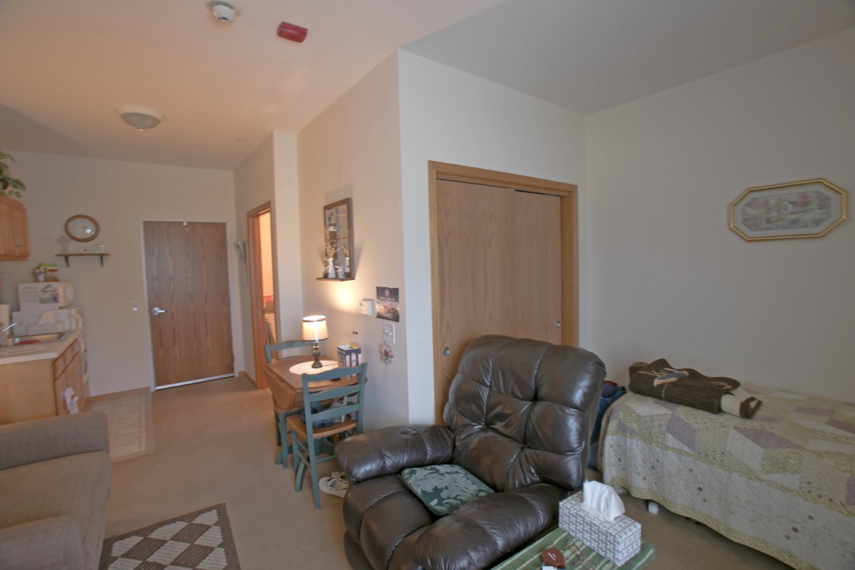 A cozy living room with a recliner and a small desk.