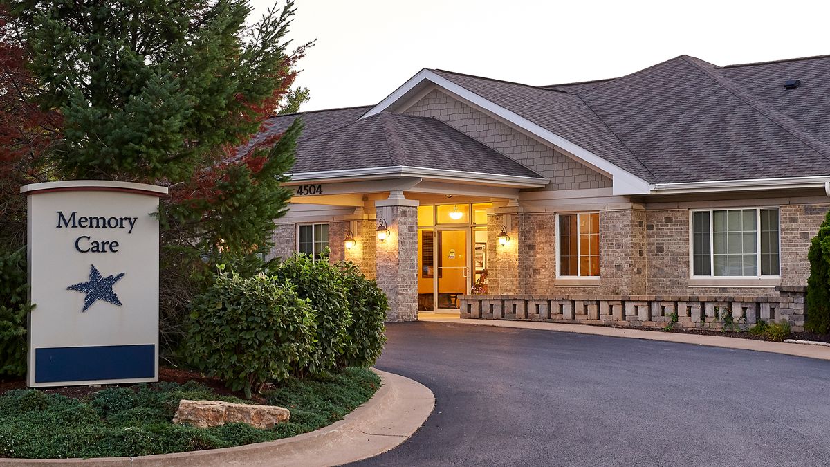 A welcoming building entrance with well-maintained landscaping and a clean driveway.