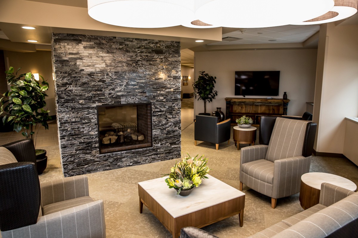 Modern lobby with a cozy seating area and a stone fireplace.