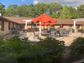 Outdoor patio with red umbrellas and seating.