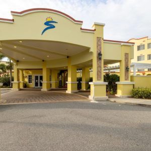 A hotel entrance with a yellow exterior and an arched roof.