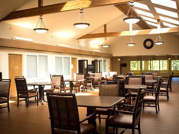 A well-lit dining area with multiple tables and chairs arranged neatly in a spacious room.