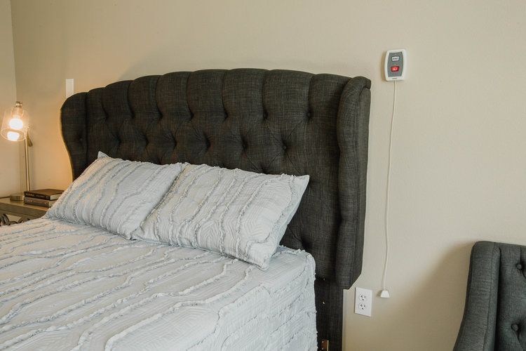 A cozy bedroom with a tufted headboard and neatly arranged bedding.