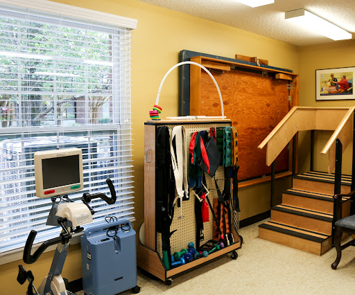 A well-equipped rehabilitation therapy room featuring exercise equipment and a staircase.