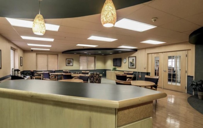 A spacious cafeteria with modern lighting and furniture.