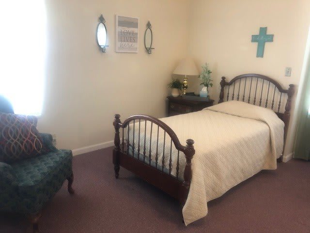 A cozy bedroom with a single bed, decorative accents, and comfortable seating.