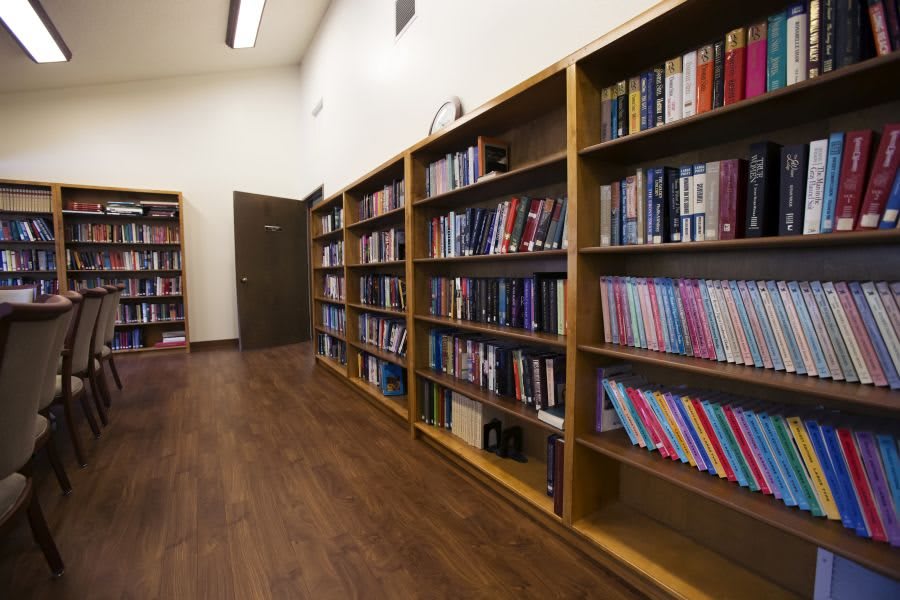 A quiet library aisle lined with bookshelves filled with various books.