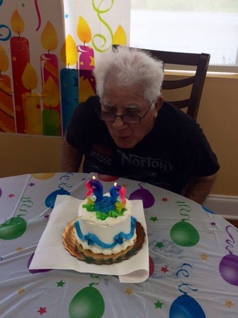 A person preparing to blow out candles on a birthday cake at a celebration.