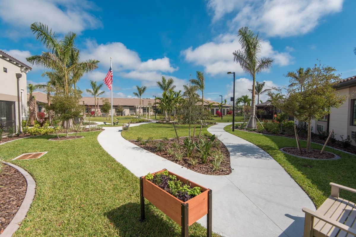 A beautifully landscaped garden with winding pathways and lush greenery under a clear blue sky.