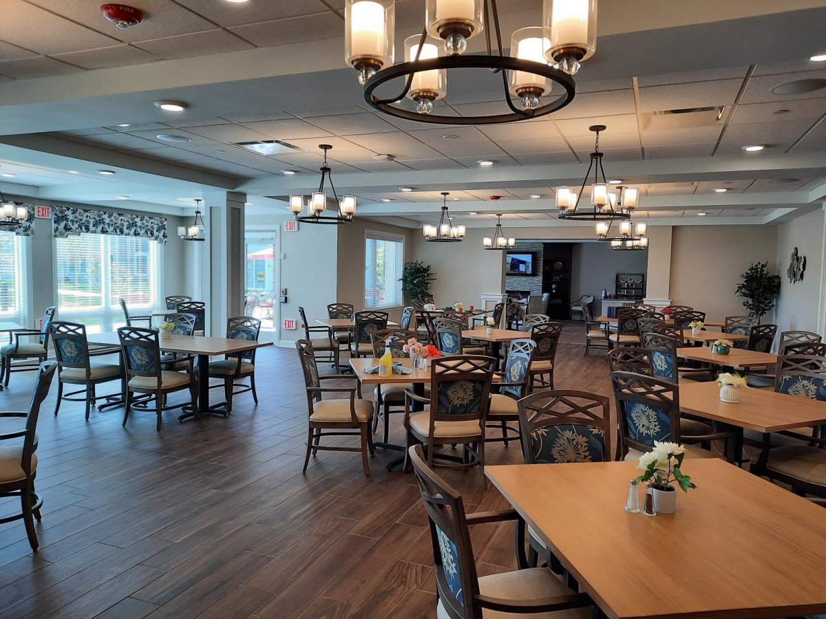 A spacious dining area with neatly arranged tables and decorative lighting.