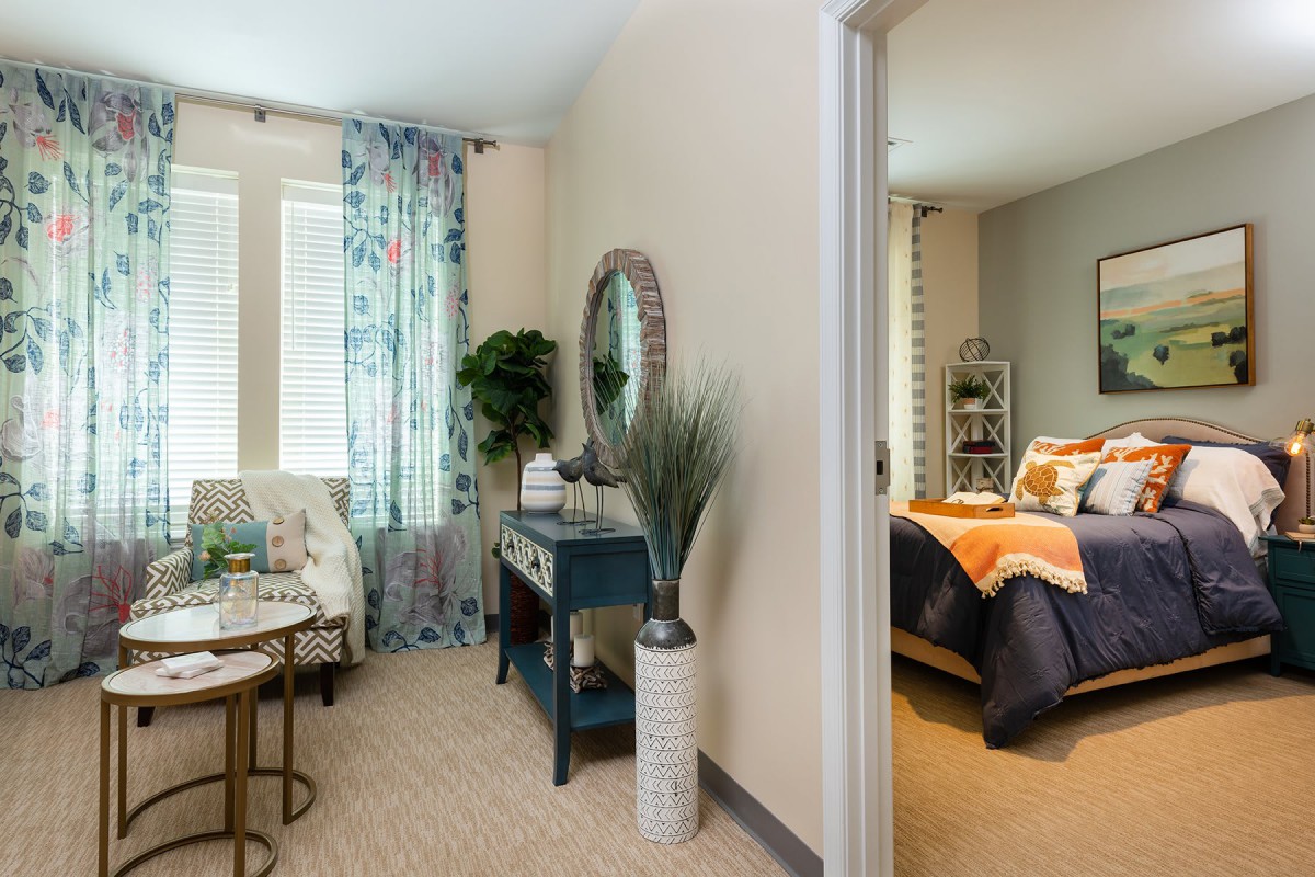 A cozy and stylish interior featuring a living room and an adjacent bedroom with modern decor accents.