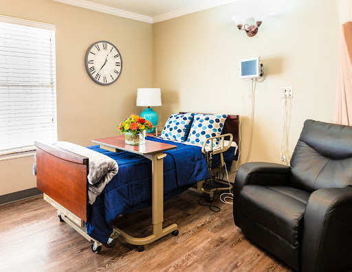 A cozy hospital room equipped with a patient bed, medical supplies, and home-like decor.