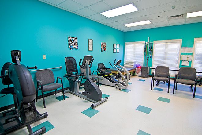 A bright, indoor fitness center featuring stationary bikes and comfortable seating.