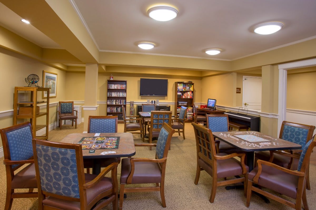 A cozy indoor leisure room with tables and bookshelves.
