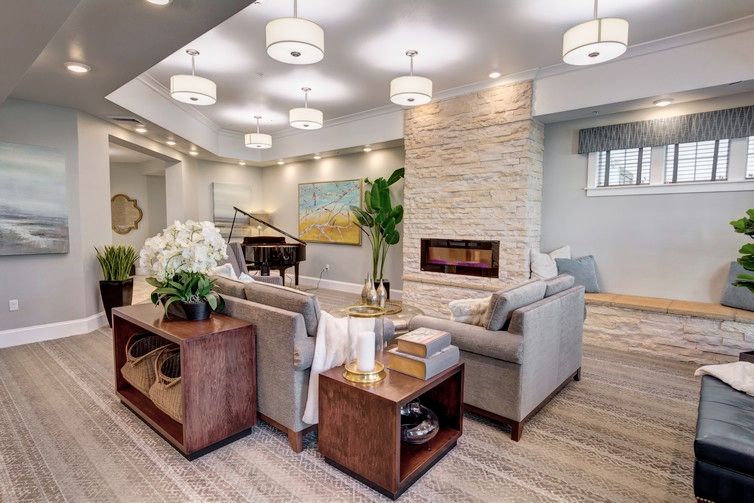 A modern living room with stylish furniture, a fireplace, and a grand piano.