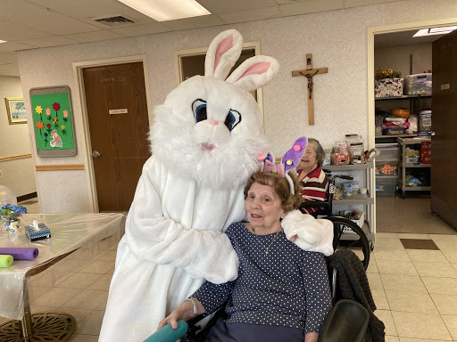 A joyful moment during an Easter celebration, featuring a person in a bunny costume with an elderly individual.