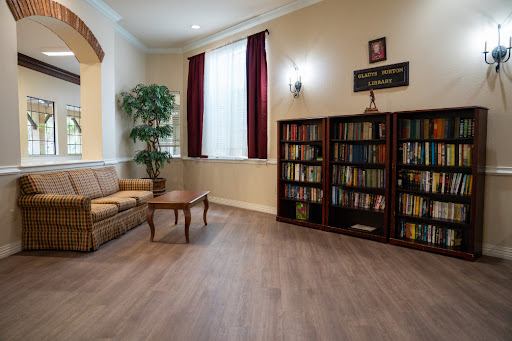 A cozy living room featuring a bookshelf filled with books, a comfortable sofa, and warm lighting.