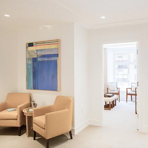 A stylish and modern waiting room featuring comfortable seating and contemporary artwork.