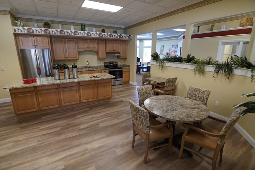 A cozy kitchen and dining area with wooden cabinets and round table.