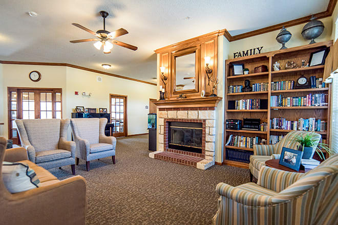 Cozy living room with a fireplace, bookshelves, and comfortable seating.