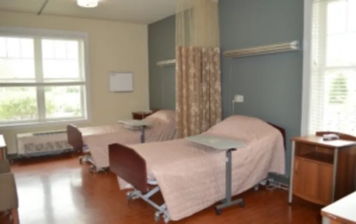 A hospital room with two beds separated by curtains.