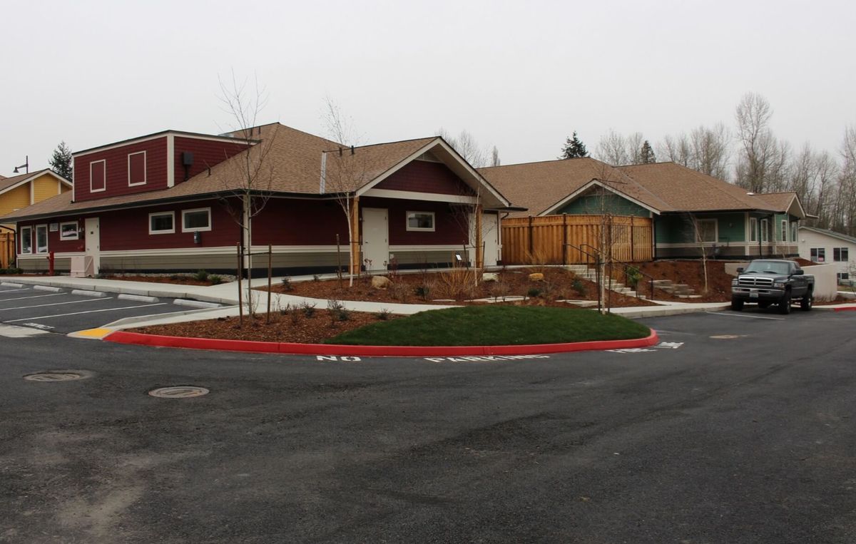A suburban residential house with a driveway and landscaped yard.