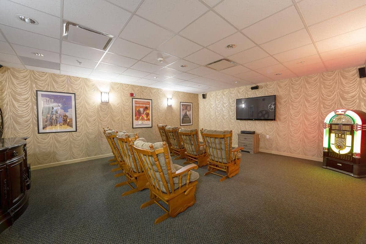 A cozy home theater room with comfortable seating and a large screen.