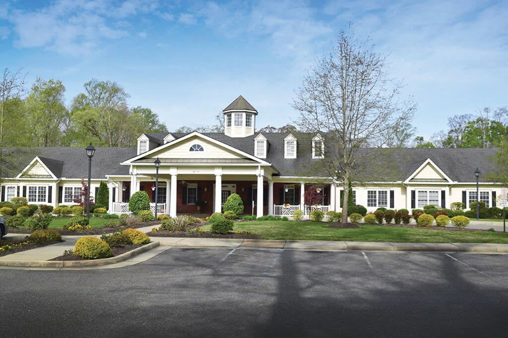 A picturesque residential building with well-maintained landscaping in a suburban setting.