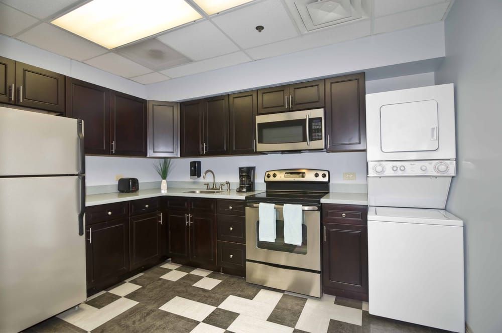 Modern kitchen with dark cabinets and stainless steel appliances.