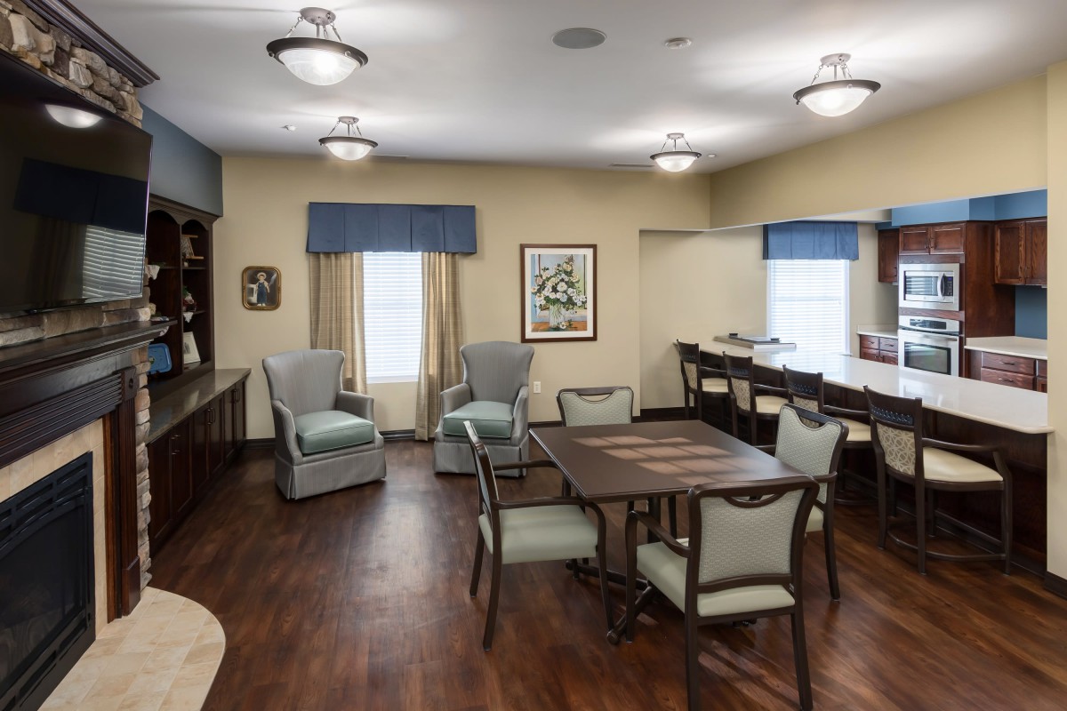 A cozy living room with comfortable seating, a table, and ample lighting.