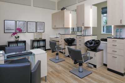 A modern hair salon interior with styling chairs and sinks.